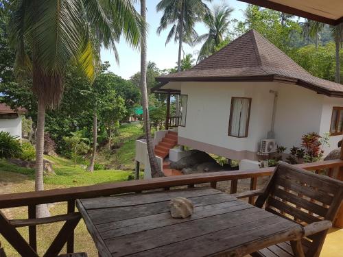 een houten tafel voor een huis bij Diamond Beach Resort in Ko Tao