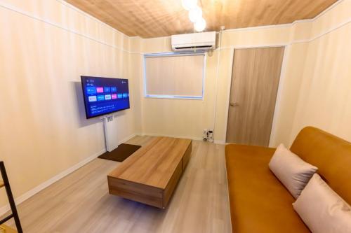 a living room with a couch and a flat screen tv at Darin中洲北 2F in Fukuoka