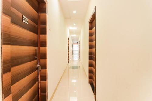 a hallway with wooden doors and a hallway with white walls at Hotel O Unique Inn in Dhule
