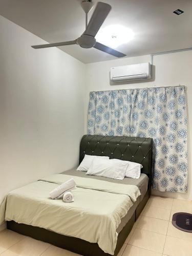 a bedroom with a bed with a ceiling fan at FE Homestay in Tawau