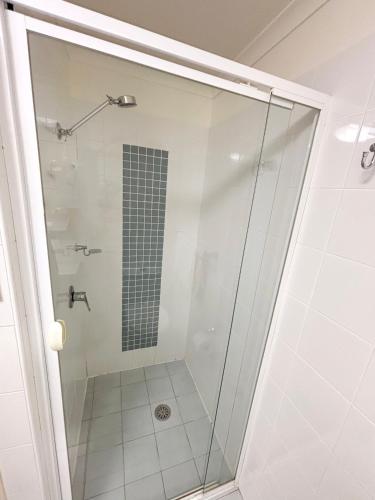 a shower with a glass door in a bathroom at Jubilee Apartment 14 in South West Rocks