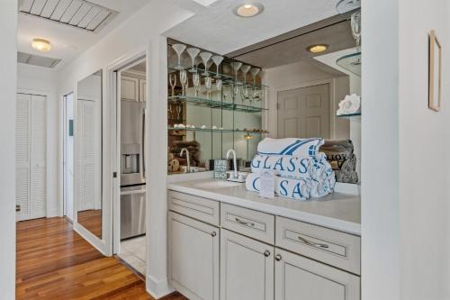 a kitchen with white cabinets and a large sink at Seaside Rendezvous in Sanibel