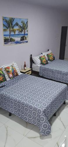 two beds in a room with palm trees at Apartment Torres in Manuel Antonio