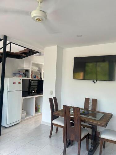 a dining room with a table and chairs and a refrigerator at Casa Sol & Descanso Tocaima in Tocaima