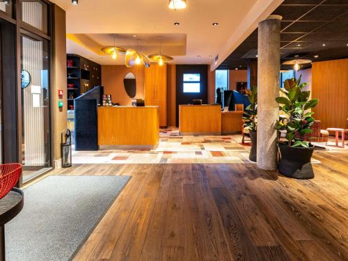 an office lobby with wooden flooring and a waiting area at Novotel Suites Reims Centre in Reims