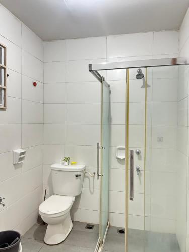 a bathroom with a toilet and a glass shower at FE Homestay in Tawau