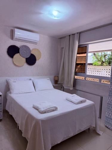 a bedroom with a white bed and a window at Sol e Mar Solar do Atlântico-Tambaú-João Pessoa in João Pessoa