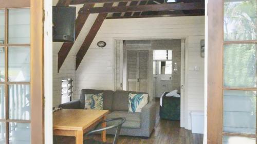 a living room with a couch and a table at Picnic Bay Chalet Unit 2 in Picnic Bay