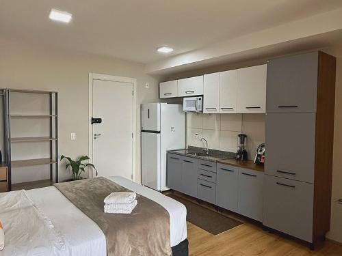 a kitchen with white cabinets and a white refrigerator at Franklin Studio Prime Rio Energy - Piscina, Sauna, Academia in Rio de Janeiro