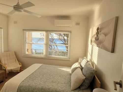 a bedroom with a bed and a window at Esplanade Bliss in Cronulla