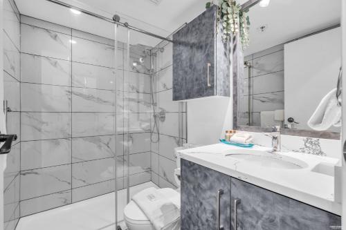 a bathroom with a shower and a sink and a toilet at Central Alpine Condo in Whistler