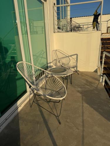 a patio with two chairs and a table on a balcony at Beach house in San Miguel, Ensenada in Ensenada