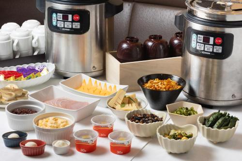 a counter topped with bowls of different types of food at Hotel Bel Air Sendai in Sendai