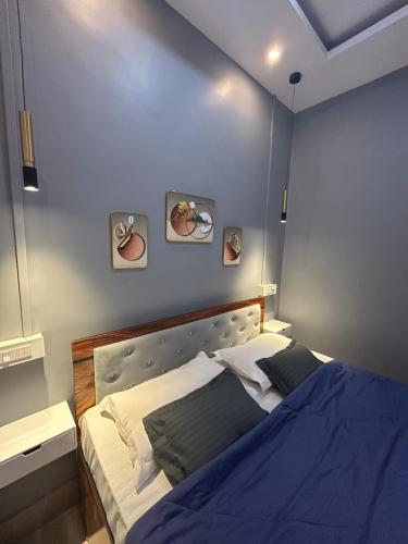 a bedroom with a bed with a blue wall at Pearl Haven in Jorhat