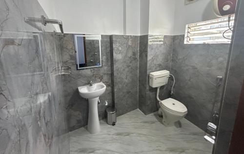 a bathroom with a toilet and a sink at Pearl Haven in Jorhat