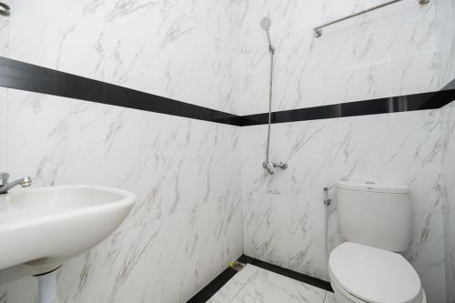 a bathroom with a white toilet and a sink at RedDoorz Plus near Politeknik Negeri Malang in Malang