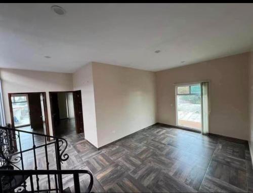 an empty room with a wooden floor and a staircase at CasaLyz in Rosarito Beach