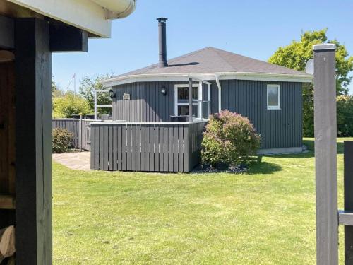 a blue house with a fence in a yard at 4 person holiday home in Vinderup in Vinderup