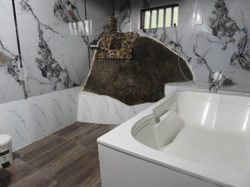 a white bath tub in a bathroom with marble walls at hotel campestre san antonio in Campoalegre