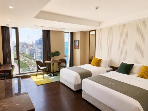 a hotel room with two beds and a window at Western Palace Hotel in Incheon