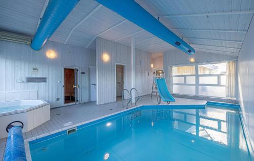 a large swimming pool with a slide in a room at Strandpark 9 in Schönhagen