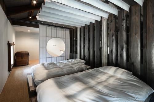 a bedroom with two beds and a wall of wood at 一乗谷 朔 saku in Fukui