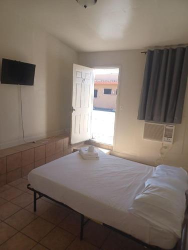 a bedroom with a large bed with a window at Sunset Motel in Las Vegas