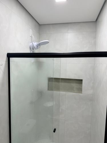 a glass shower door with a silver object on it at Residencial Ebenezer conforto perto da ufac in Rio Branco