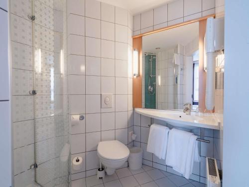 a bathroom with a toilet and a sink and a shower at Ibis Kaunas Centre in Kaunas