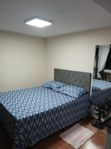 a bedroom with a bed with a blue comforter at Loft Meu Aconchego in Nova Friburgo