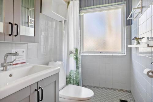 a bathroom with a sink and a toilet and a window at 20103-Samso-Teglvaerksvej-2 in Brundby
