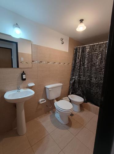 a bathroom with a toilet and a sink at Complejo Los Arrayanes - Plottier in Plottier