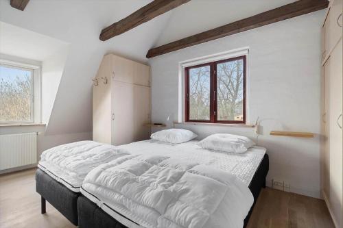a bedroom with a large bed with white sheets at 20333-Samso-Havvejen-61 in Sælvig