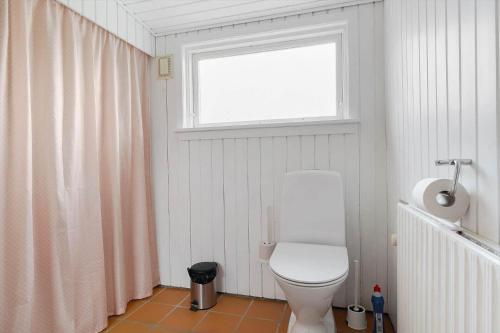 a bathroom with a white toilet and a window at 20333-Samso-Havvejen-61 in Sælvig