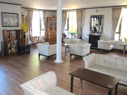 a living room with couches and chairs and a table at Chateau Le Fleur in Ito
