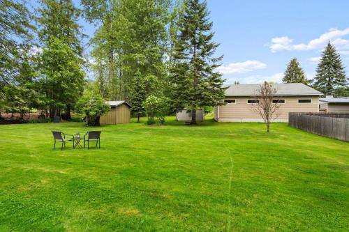 a yard with two chairs and a table in it at Cedar Trees Retreat in Sandpoint