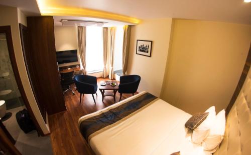 a hotel room with a bed and a table and chairs at Connaught Royale Delhi in New Delhi