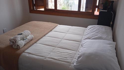 a bed with two towels on it in a bedroom at Pousada da Lú in Jaguarão