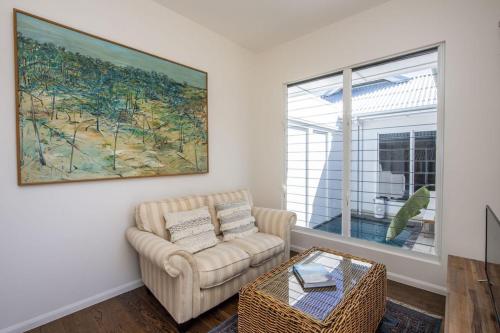 a living room with a chair and a painting on the wall at Reflections Turquoise Villa 4 in Picnic Bay
