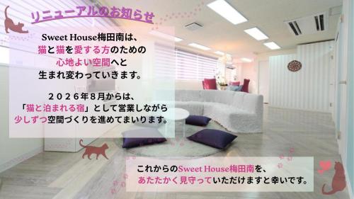 a living room with a couch and a dog on the wall at Sweet House Umeda Minami in Osaka