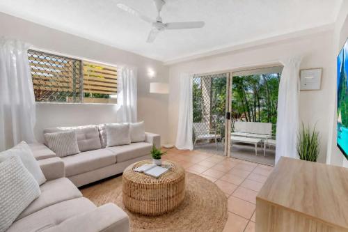 a living room with a couch and a table at Wallaby Beach House - Resort-style Comforts in Trinity Beach