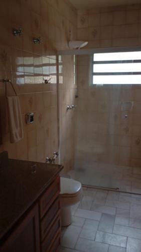 a bathroom with a shower and a toilet and a sink at Pousada da Lú in Jaguarão