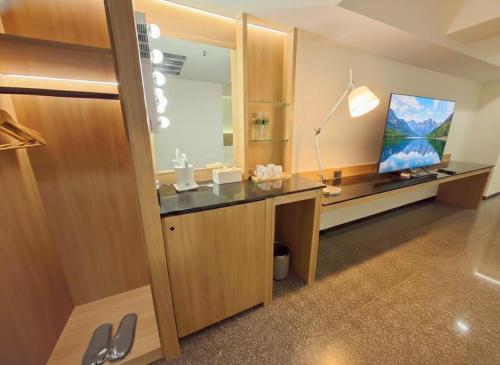 a bathroom with a desk with a tv and a mirror at Fosen Hotel in Taichung