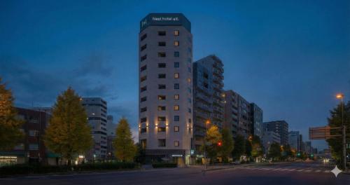 a tall building with a sign on the top of it at Nesthotel alt Kuramae Station in Tokyo