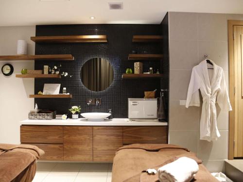 a bathroom with a sink and a mirror at The Sebel Melbourne Docklands Hotel in Melbourne