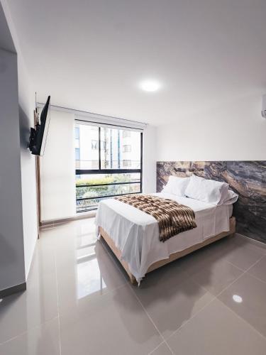 a bedroom with a bed and a large window at Colseguros in Cali