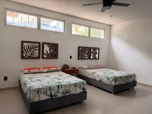 two beds in a room with two windows at Vistas del Angel in San Juan Cosalá