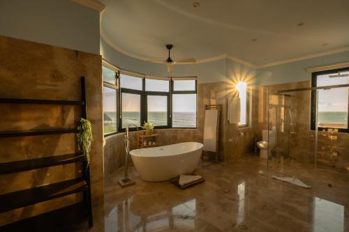 a large bathroom with a large tub and a window at Luxury 7 Bedroom Oceanfront Villa at Hacienda Tankah with Infinity Pool & Premium Hospitality in Tulum