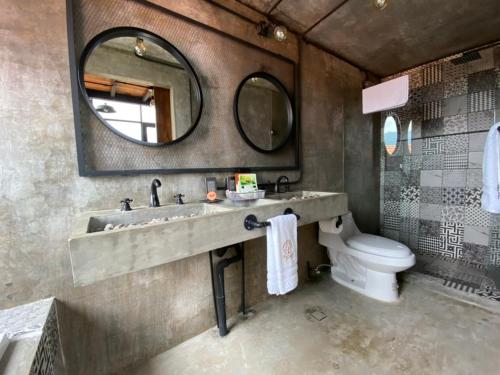 a bathroom with a sink and a toilet and a mirror at Macpalo in Amatlán