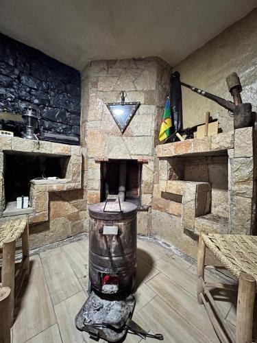 a room with a large stone fireplace in a room at Gîte Touften in Aït Aïouz